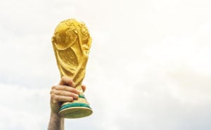 A man holding a replica FIFA World Cup